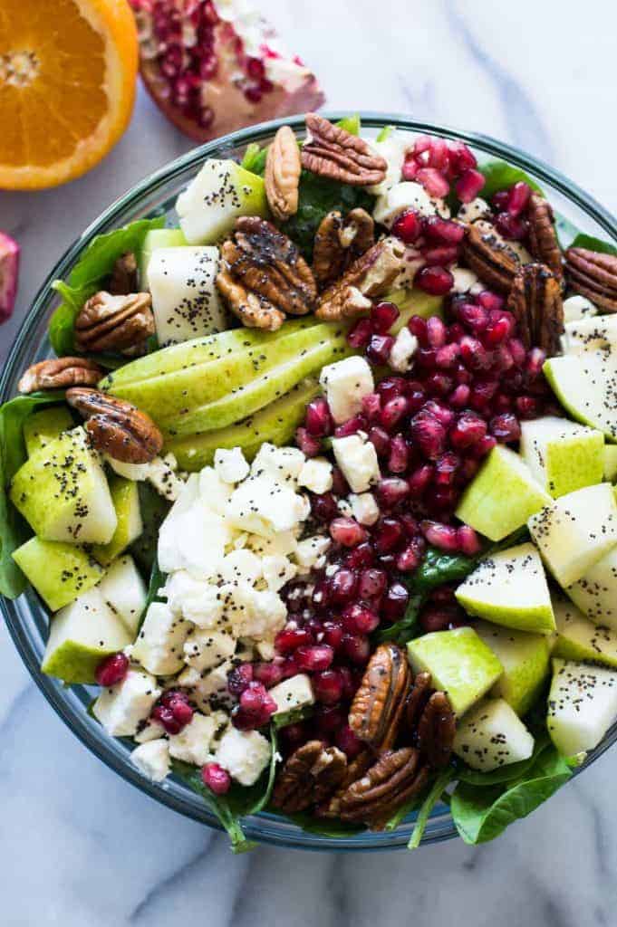 Pear & Pomegranate Salad with Orange Poppyseed Vinaigrette. This salad is loaded up with juicy pear, tart pomegranate, pecans, feta, all on a bed of fresh baby spinach and drizzled with a citrus orange poppyseed vinaigrette. This beautiful salad will be the highlight of any meal! The colors are perfect for any Holiday spread too! 