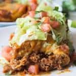 Smothered Burrito! These large burritos are bursting with ground beef simmered in a homemade taco seasoning, smooth and creamy refried beans, and lots of melty cheese! Then smothered in homemade chili gravy and even more cheese! Hearty, savory, and comforting! These easy smothered burritos will quickly become a favorite dinner!