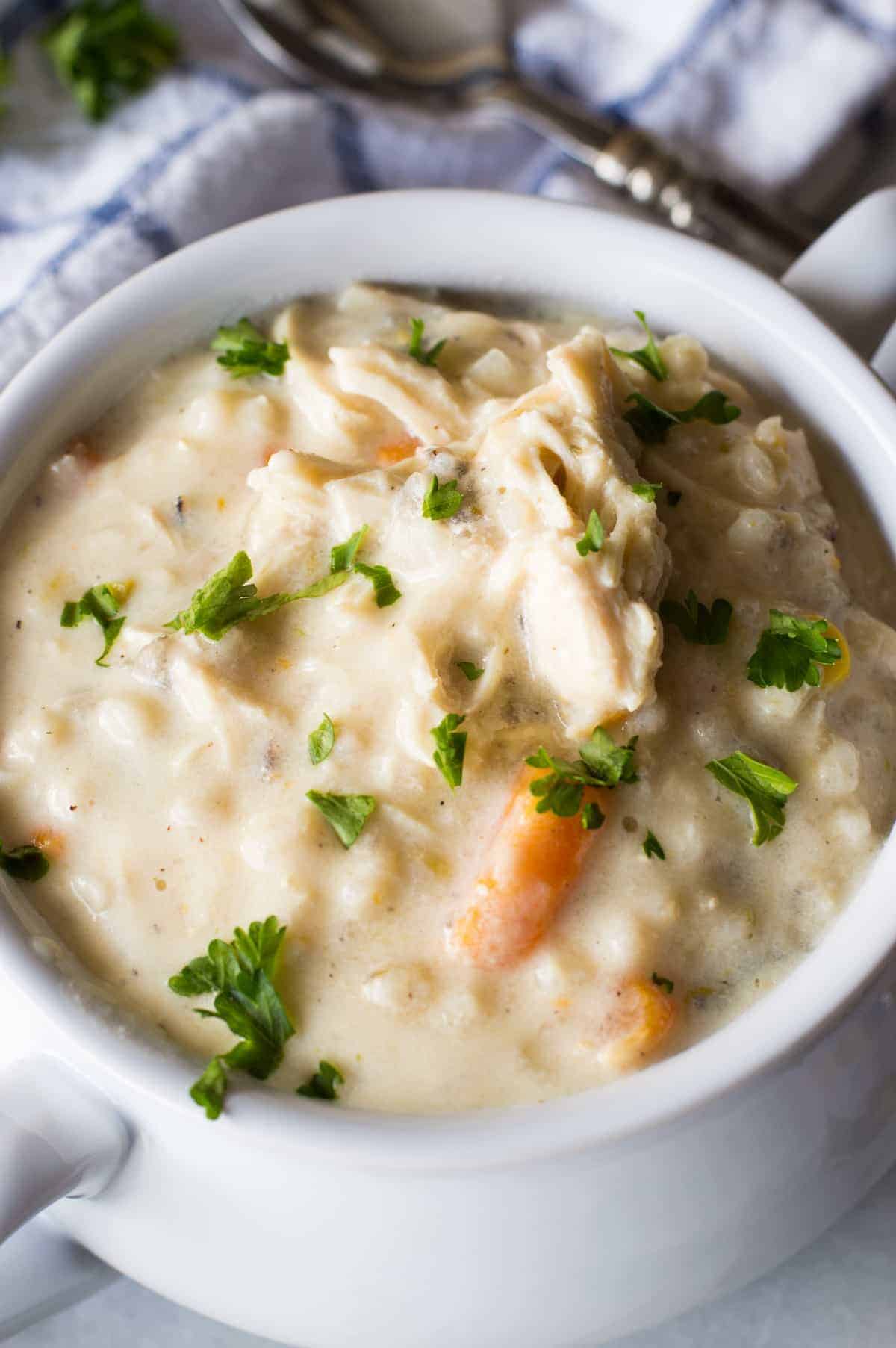 Slow Cooker Creamy Chicken and Wild Rice Soup! This soup is ultra creamy, ultra flavorful, and best part? There's no actual cream or butter used! This is the perfect lighter version of a classic comfort food. 