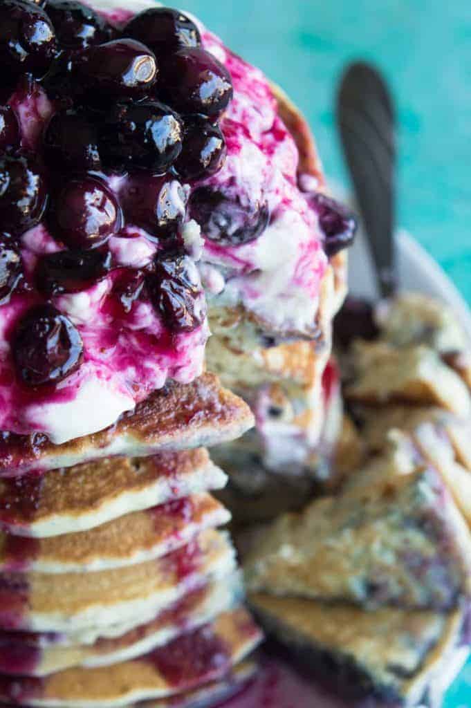 Blueberry Cheesecake Pancakes! Soft pancakes bursting with juicy blueberries. Topped with a fluffy cheesecake topping and a homemade blueberry sauce. You will want to start everyday with this breakfast! Life just doesn't get any better.