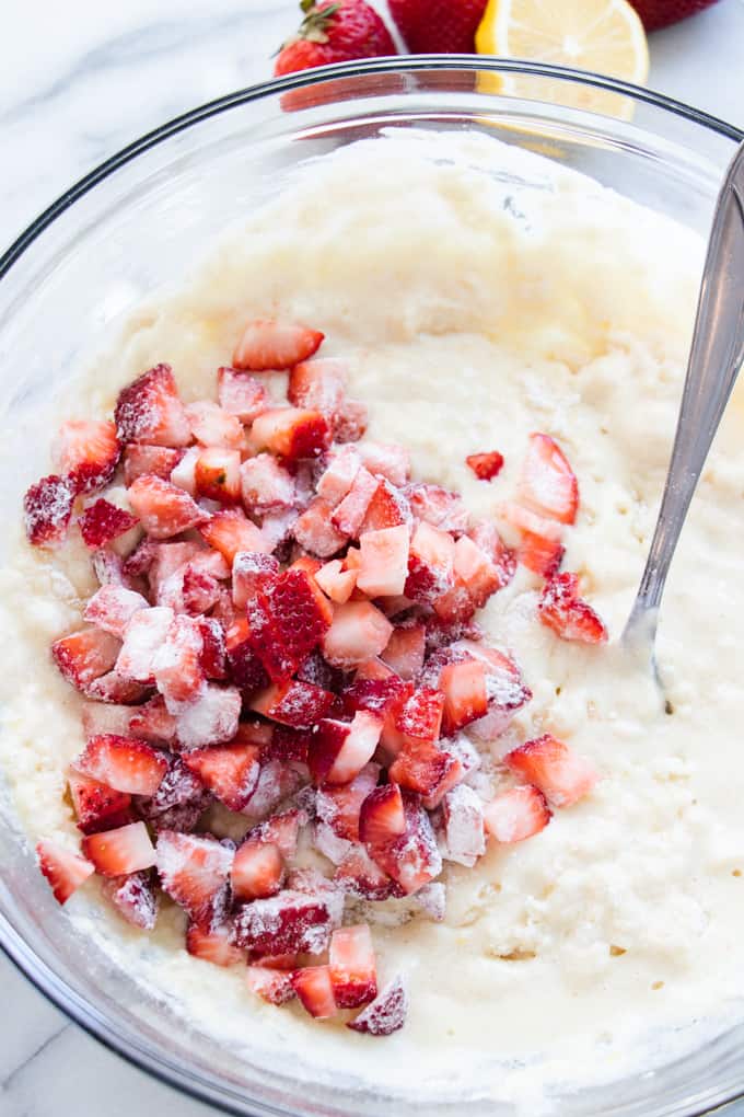 Batter for pound cake with diced strawberries on top.