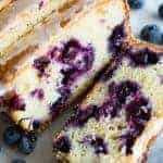 Blueberry Lemon Pound Cake! This pound cake is made lighter by using greek yogurt, and is loaded up with lemon flavor thanks to zest and fresh lemon juice! Juicy blueberries are baked right in. All drizzled with a luscious lemon glaze.