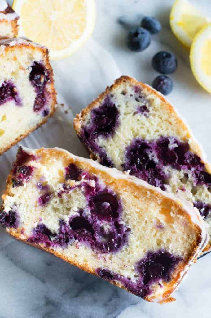 Blueberry Lemon Pound Cake! This pound cake is made lighter by using greek yogurt, and is loaded up with lemon flavor thanks to zest and fresh lemon juice! Juicy blueberries are baked right in. All drizzled with a luscious lemon glaze. 