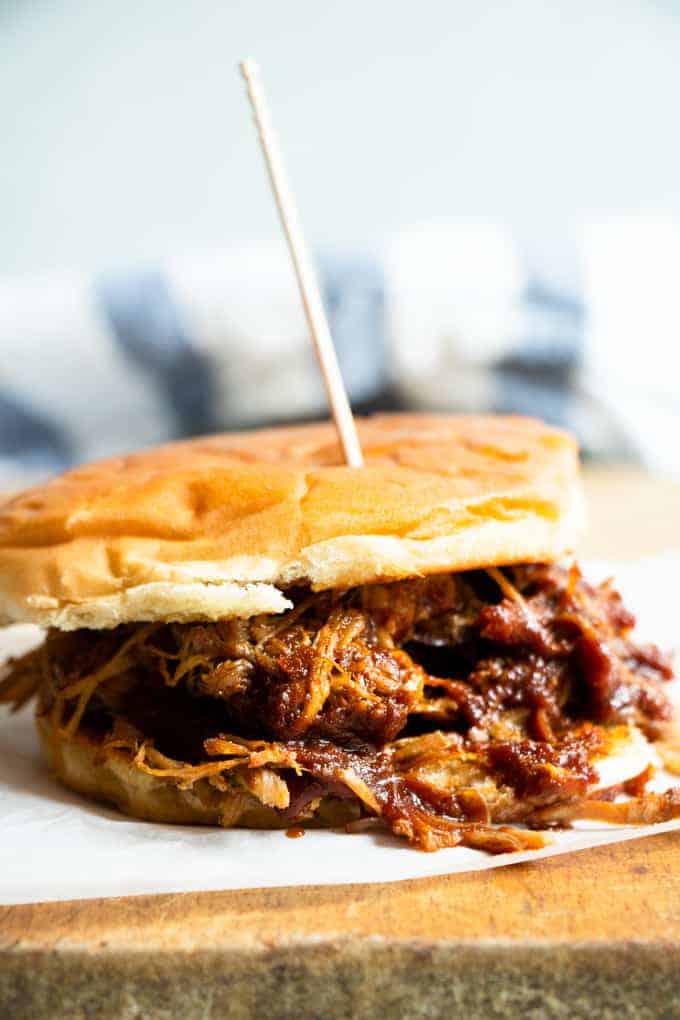 Slow cooker pulled pork mixed with a Texas style BBQ sauce on a bun making a pulled pork sandwich.