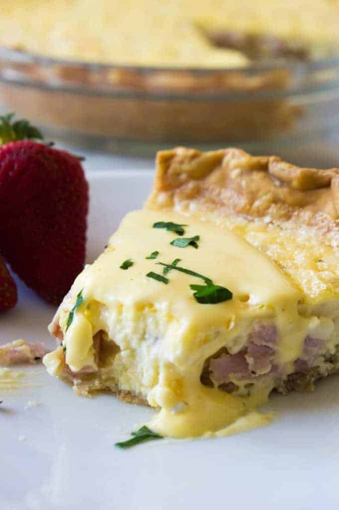 Eggs Benedict Quiche! This super easy to make quiche comes out with perfectly flakey crust, creamy egg and bites of canadian bacon. Not to mention it's smothered in an easy to make blender hollandaise sauce. Perfect for brunch and upcoming Mother's Day! 