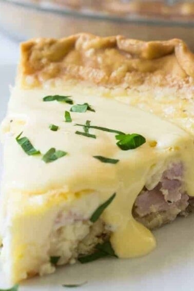 Eggs Benedict Quiche! This super easy to make quiche comes out with perfectly flakey crust, creamy egg and bites of canadian bacon. Not to mention it's smothered in an easy to make blender hollandaise sauce. Perfect for brunch and upcoming Mother's Day!
