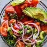 Avocado Tomato Cilantro Salad!  Refreshing and bursting with flavor this salad will be the perfect complement to any meal this summer!  Fresh tomato, avocado, cilantro all swimming in a lime dressing.  Plus top it with some crumbled queso fresco for a bit of creaminess.  