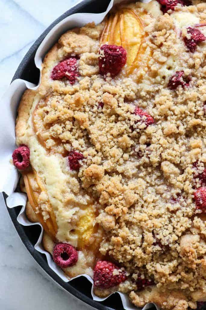 Peach Raspberry Crumb Cake!  A moist cake topped with fresh juicy peaches and sweet raspberries.  All covered in a sweet brown sugar crumb. 