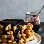 Light and fluffy whole wheat waffles made with almond milk and sweetened with maple syrup. Drizzled with a homemade organic, honey sweetened blueberry syrup.