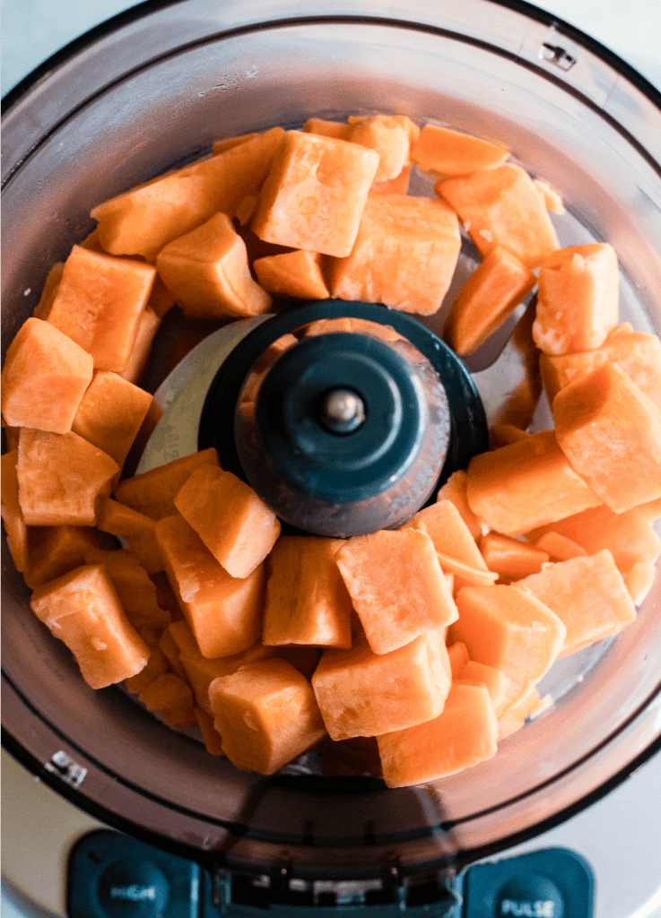 Chunks of sweet potato in a food processor to make homemade sweet potato puree.