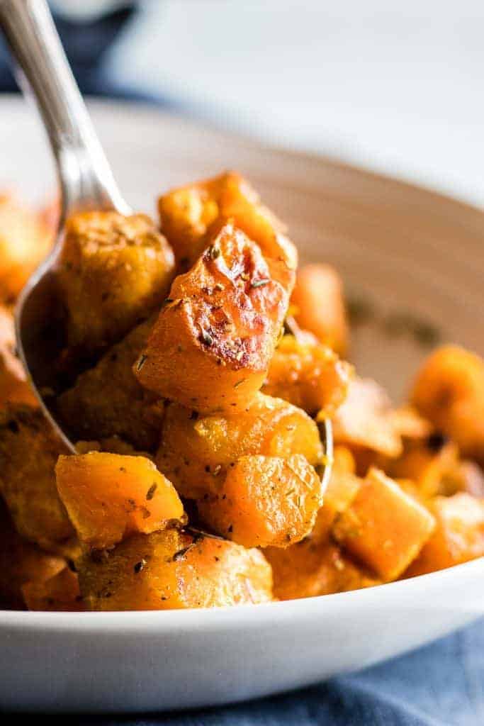 A serving spoon dishing up roasted sweet potato. 