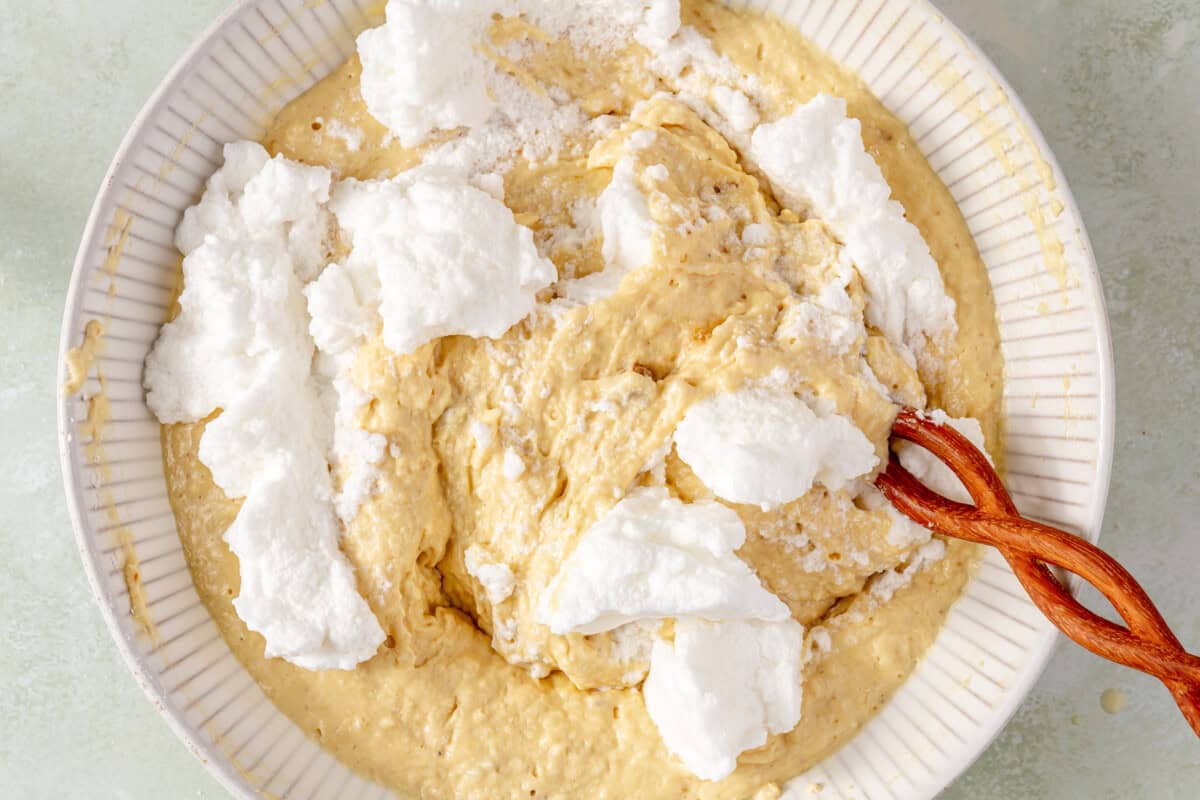 Whipped egg whites being added to waffle batter. 