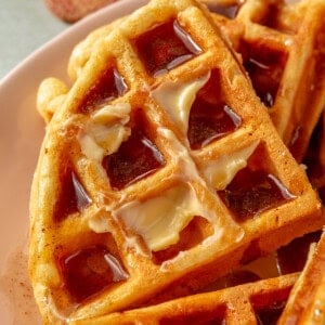 Eggnog waffles tipped with butter and drizzled with a homemade cinnamon syrup.