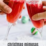 Two champagne glasses with Christmas mimosas.