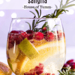 Sparkling white sangria with a sprig of rosemary.