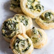Puff Pastry Spinach and Artichoke Pinwheels. This easy to put together appetizer is perfect for any party or just as a snack. Loaded with fresh spinach, artichoke, and lots of cheese! 