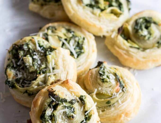 Puff Pastry Spinach and Artichoke Pinwheels. This easy to put together appetizer is perfect for any party or just as a snack. Loaded with fresh spinach, artichoke, and lots of cheese! 