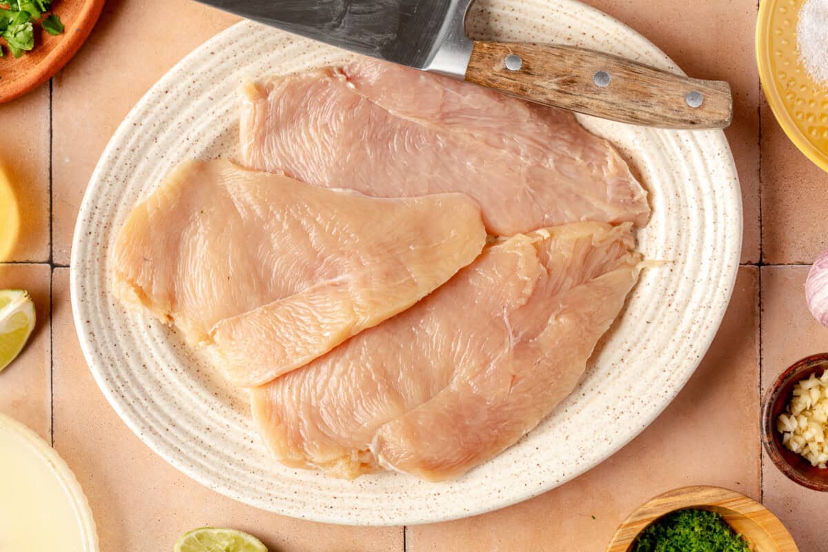 Thinly sliced chicken breasts on a plate. 