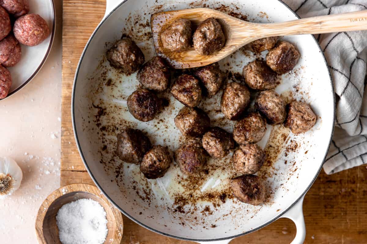 Meatballs seared in a skillet.