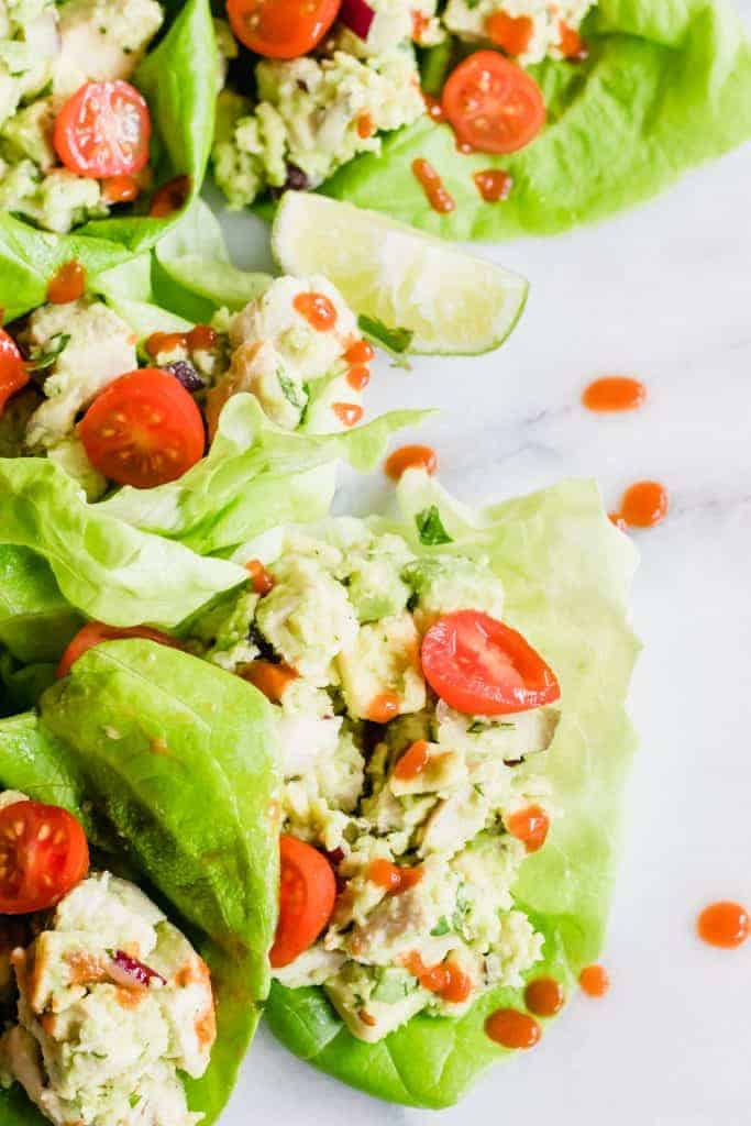 Avocado Chicken Salad with tomatoes in a lettuce wrap.
