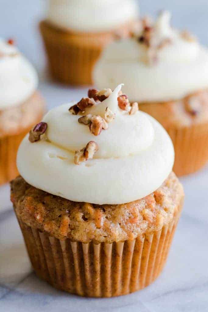 Carrot Cake Cupcake topped with a creamy, fluffy cream cheese frosting.