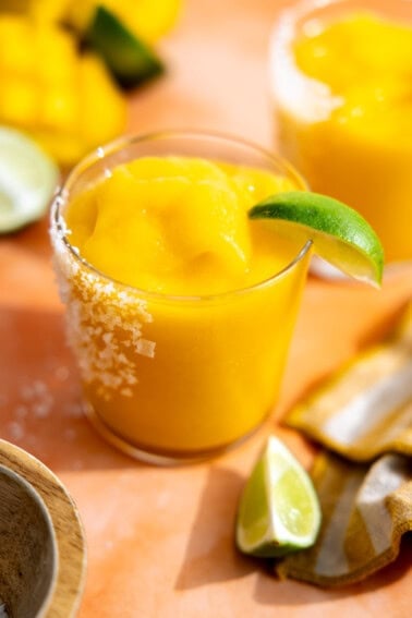 Frozen mango margarita served with a lime wedge.
