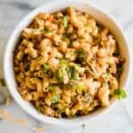 White bowl filled with cheesy one pot taco pasta topped with cilantro.