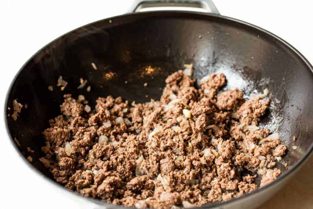 Browned ground beef in a skillet.