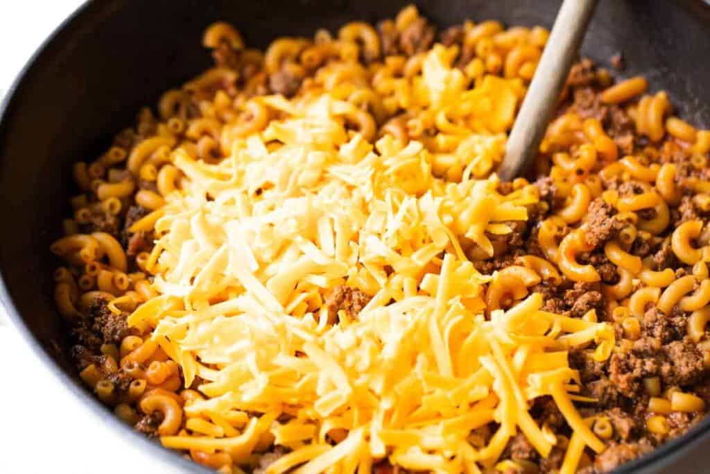 Cheese being added to taco pasta.