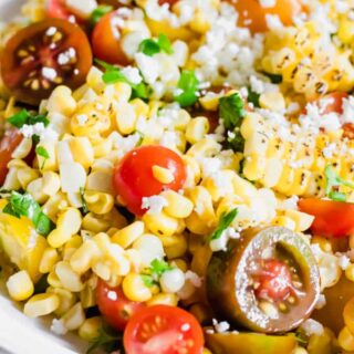 Close up of roasted corn, tomatoes, cilantro, and queso fresco in a roasted corn salad.