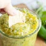 Chip dipping into jar full of pineapple salsa