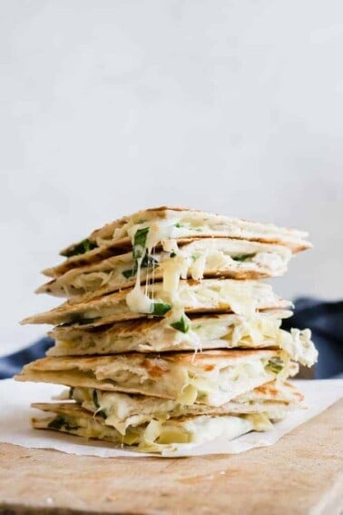 Stack of cheesy spinach and artichoke chicken quesadillas.