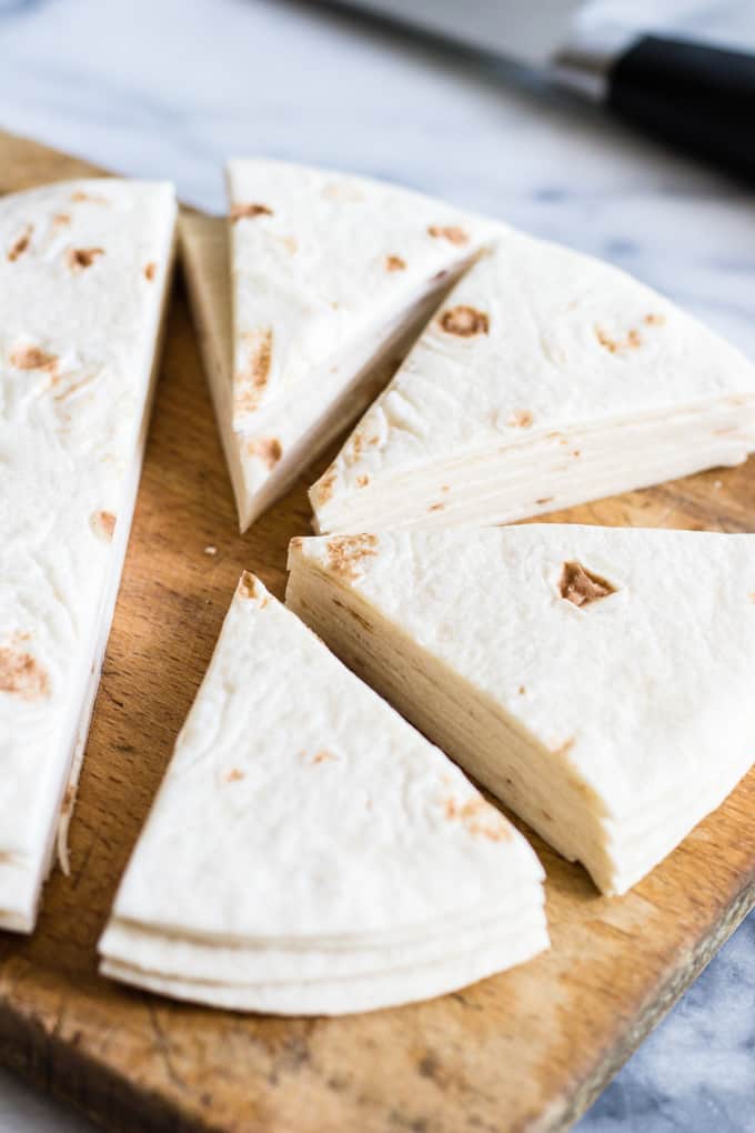 Flour tortillas cut into triangle shapes to be made into cinnamon tortilla chips