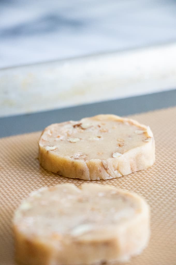Butter Pecan Shortbread cookie dough formed into rounds and placed on a baking sheet.
