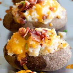 Finished twice baked potatoes, loaded with mashed potatoes, topped with melty cheese and crisp bacon pieces.