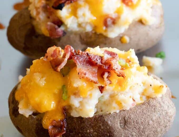 Finished twice baked potatoes, loaded with mashed potatoes, topped with melty cheese and crisp bacon pieces.