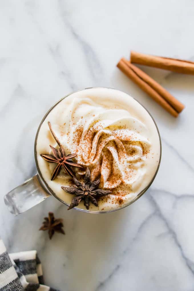 Overhead shot of a homemade apple spice latte with whipped cream and spices.