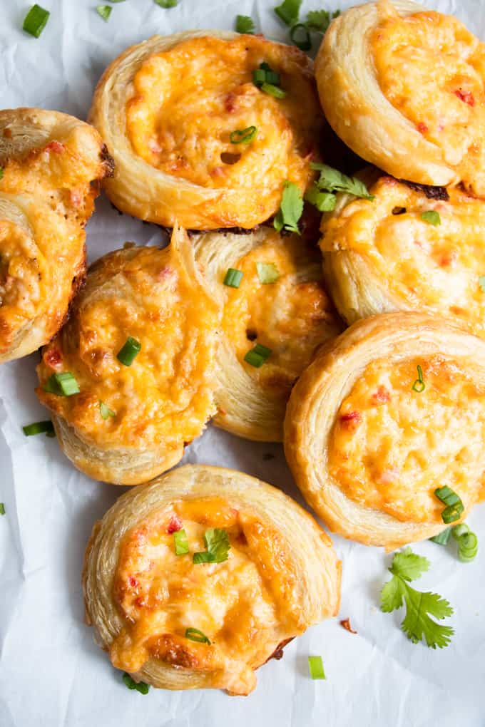 Piled up pimento cheese pinwheels garnished with green onion and cilantro. 