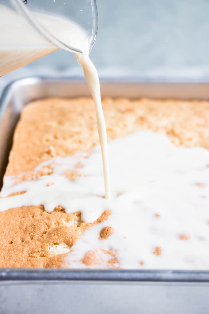 The milk mixture being poured over the top of the tres leches cake.