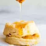 A biscuit being drizzled with honey.