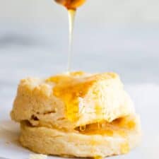 A biscuit being drizzled with honey.