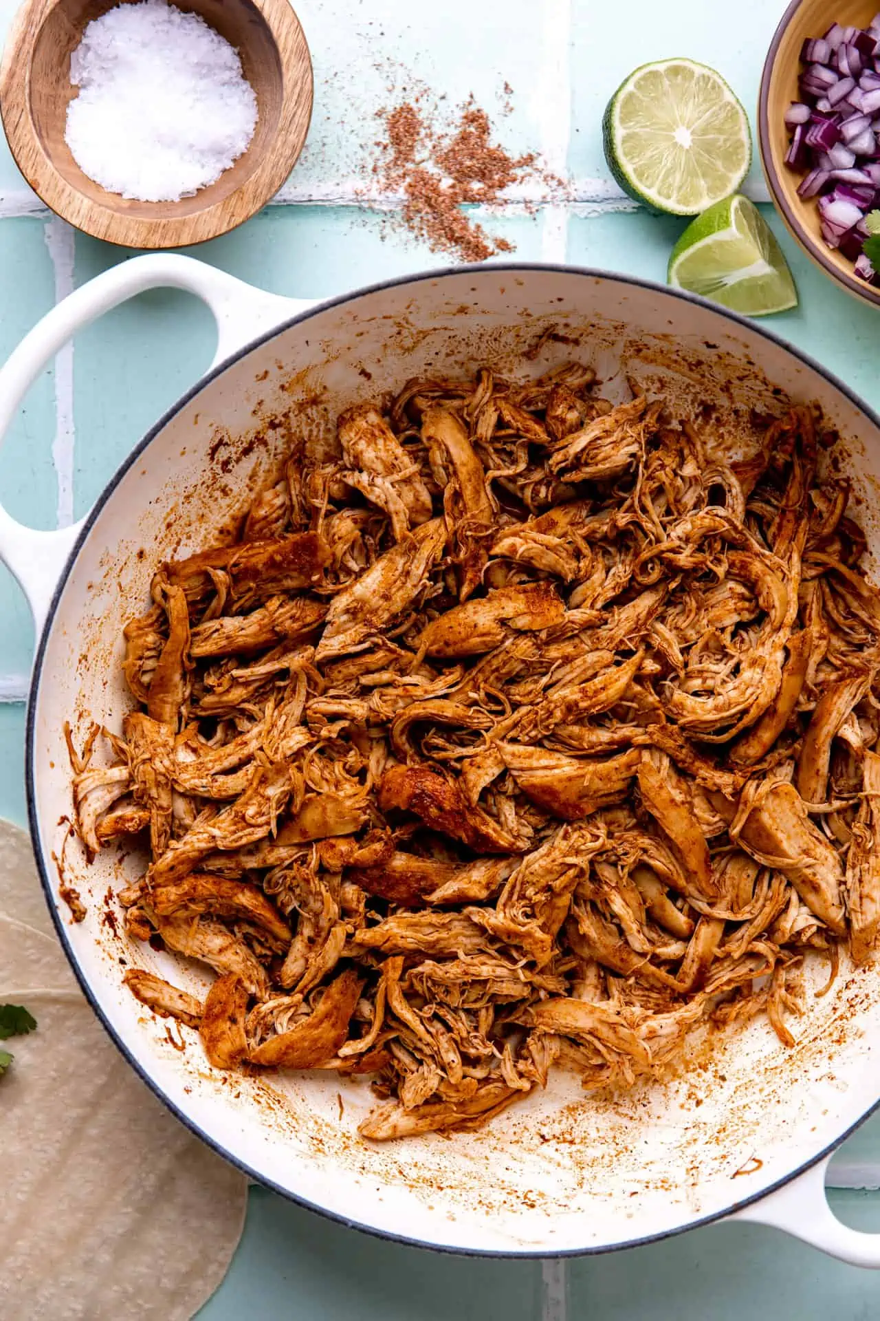 Skillet filled with shredded Mexican style chicken.