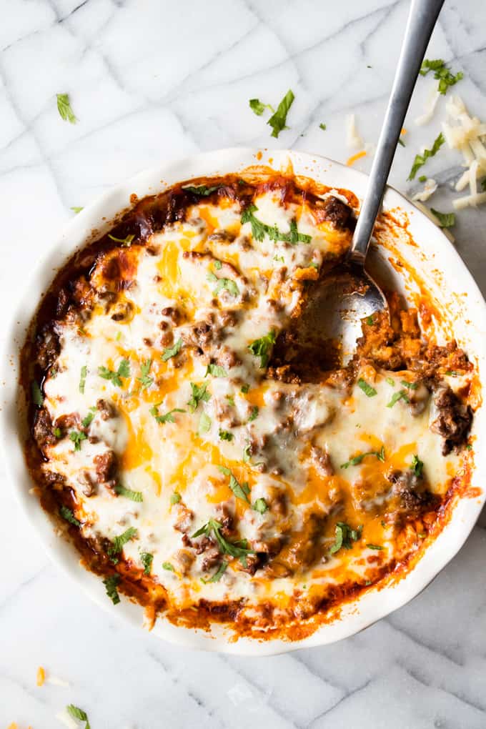 A spoon dishing up cheesy tamale pie.