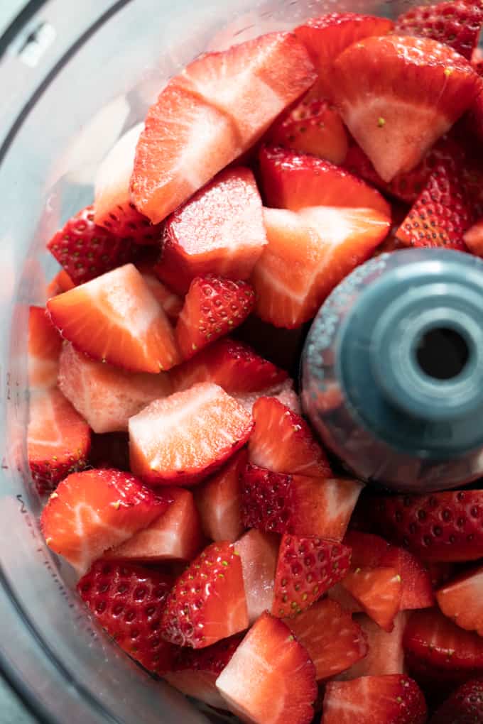 Food processor filled with fresh strawberries to make a homemade strawberry cake.