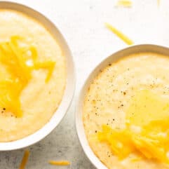 Bowls of cheese grits topped with melting butter.