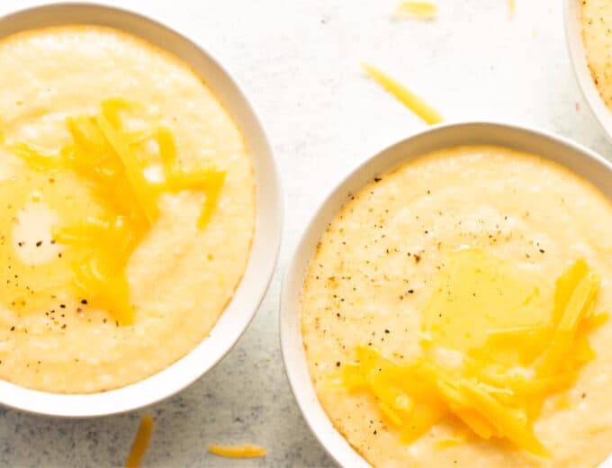Bowls of cheese grits topped with melting butter.