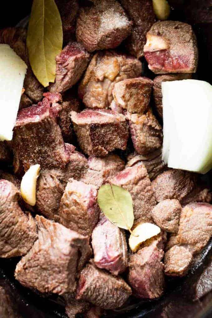 Gebratenes Chuck Roast im Slow Cooker mit Zwiebeln, Knoblauch und Lorbeerblättern.