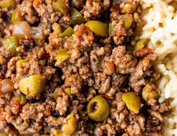 Homemade cuban picadillo served over white rice and served with a fork.