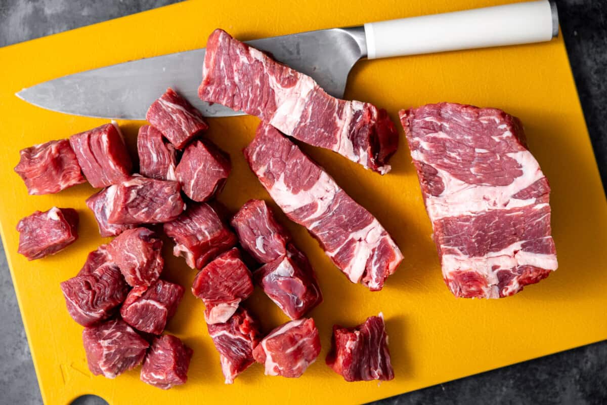 Chopped chuck roast on a cutting board with a knife.