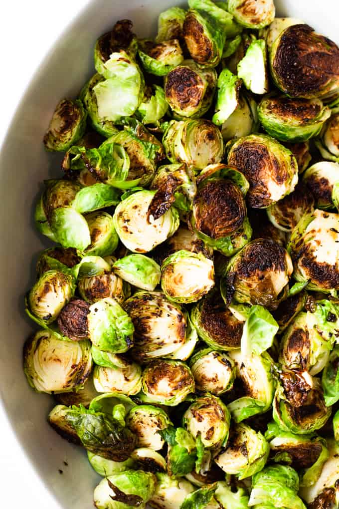 Roasted Brussels sprouts with caramelized bits in a baking dish.